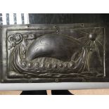 An Arts and crafts copper panel depicting a Viking longboat with similar handles.