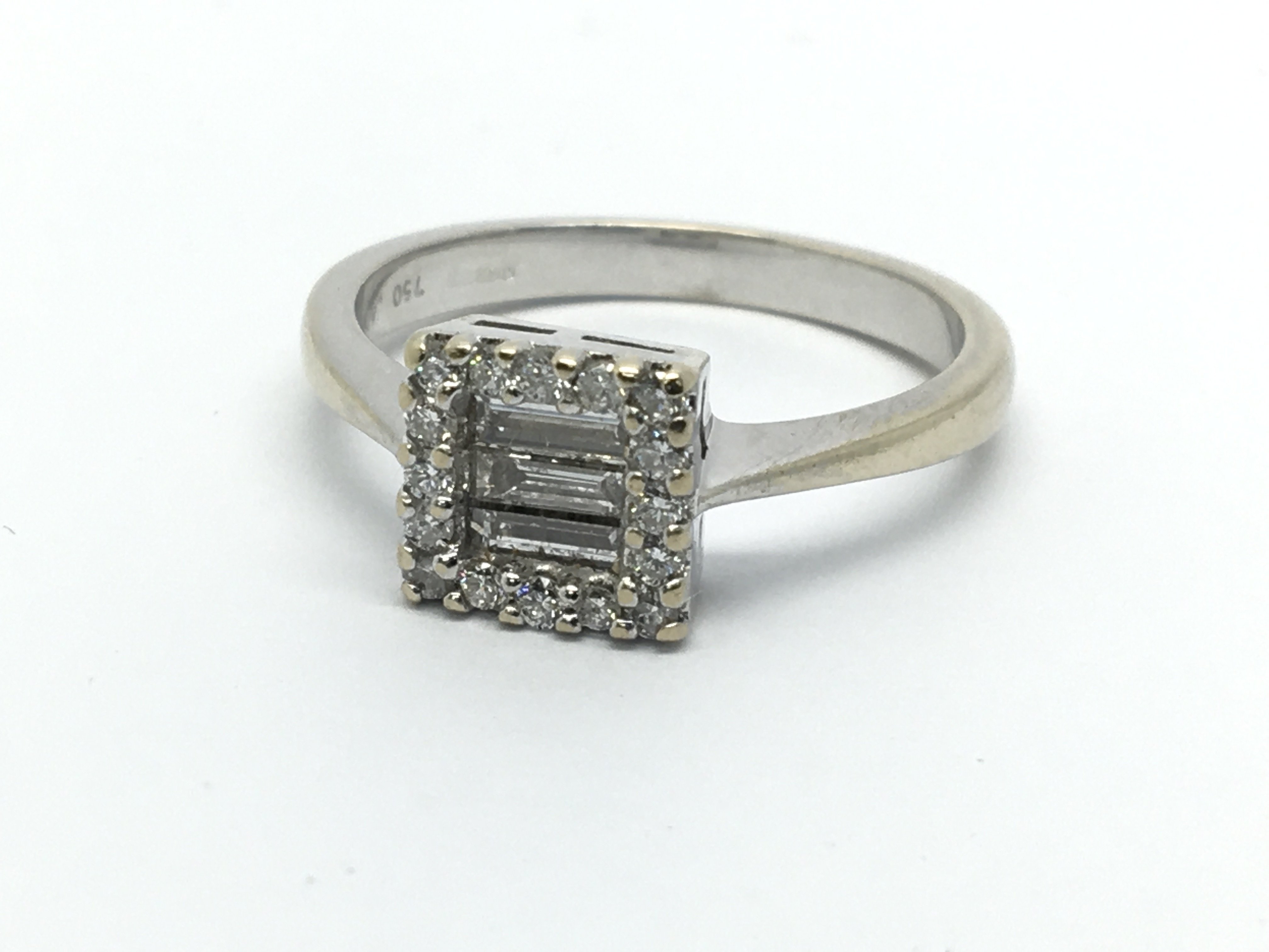 An 18ct white gold eing set with three emerald cut