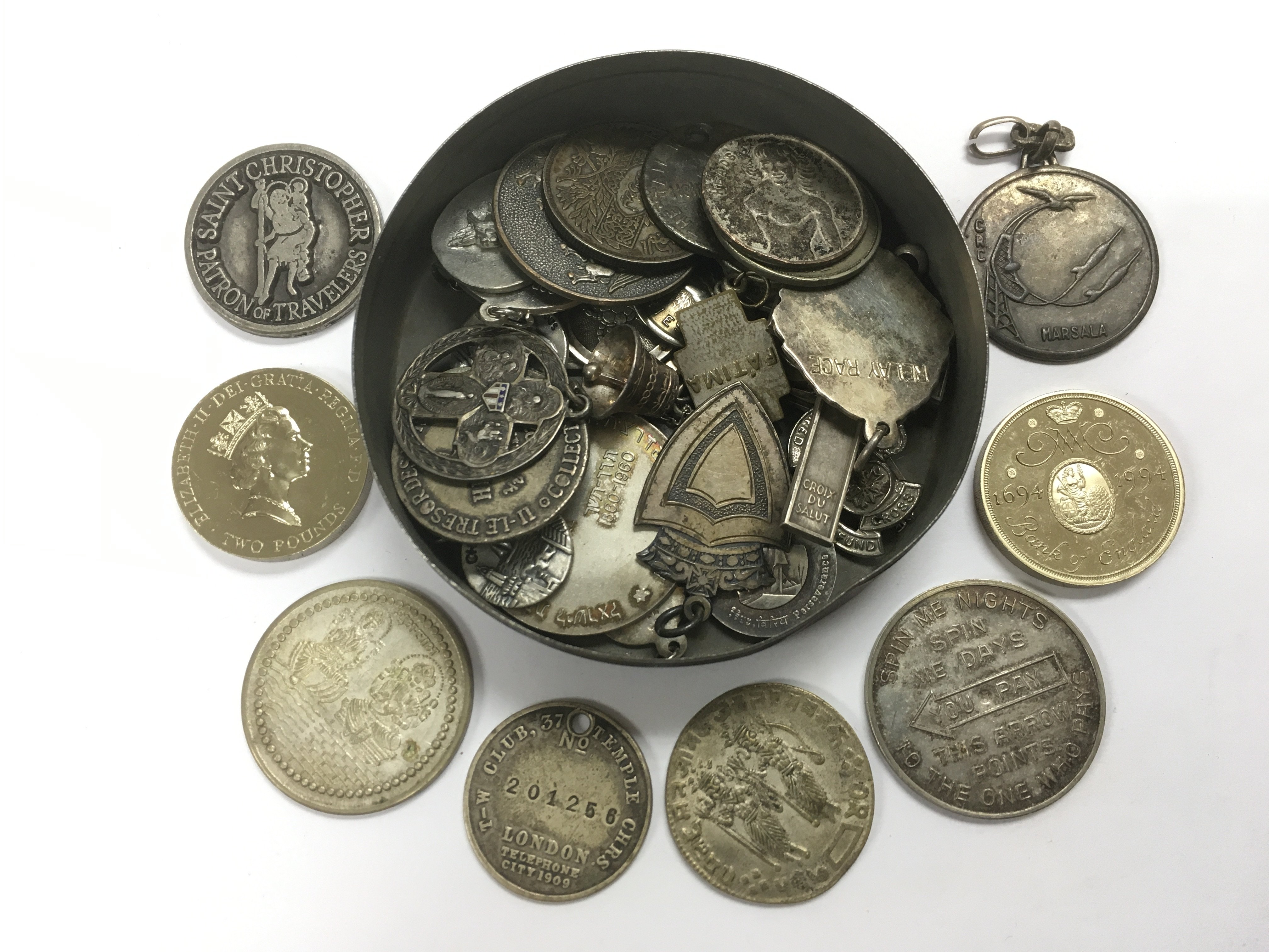 A tin of coins and medallions.