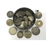 A tin of coins and medallions.