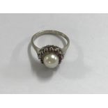 A 18 ct white gold ring inset with single pearl ru
