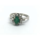 An 18ct white gold emerald and diamond cluster rin