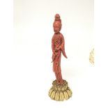 A 19th century carved coral figure on a carved ivory base in the form of bound lotus leaf height