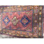 A Middle Eastern or Turkish hand knotted rug. With an unusual repeat pattern boarder with three