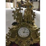 A gilt French mantel clock Surmounted by a maiden