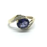 A 9ct gold ring set with a central tanzanite and s