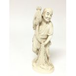 A 19th century carved ivory figure in the form of a fisherman with net a single piece carving with a