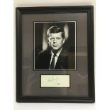 A John F Kennedy signed photo display.