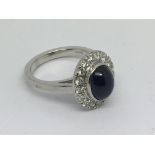 An 18ct white gold diamond and cabuchon sapphire cluster ring, approx 8.9g and approx size O.