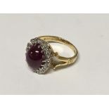 An 18carat gold ring set with a ruby cabochon flanked by diamonds ring size H-I