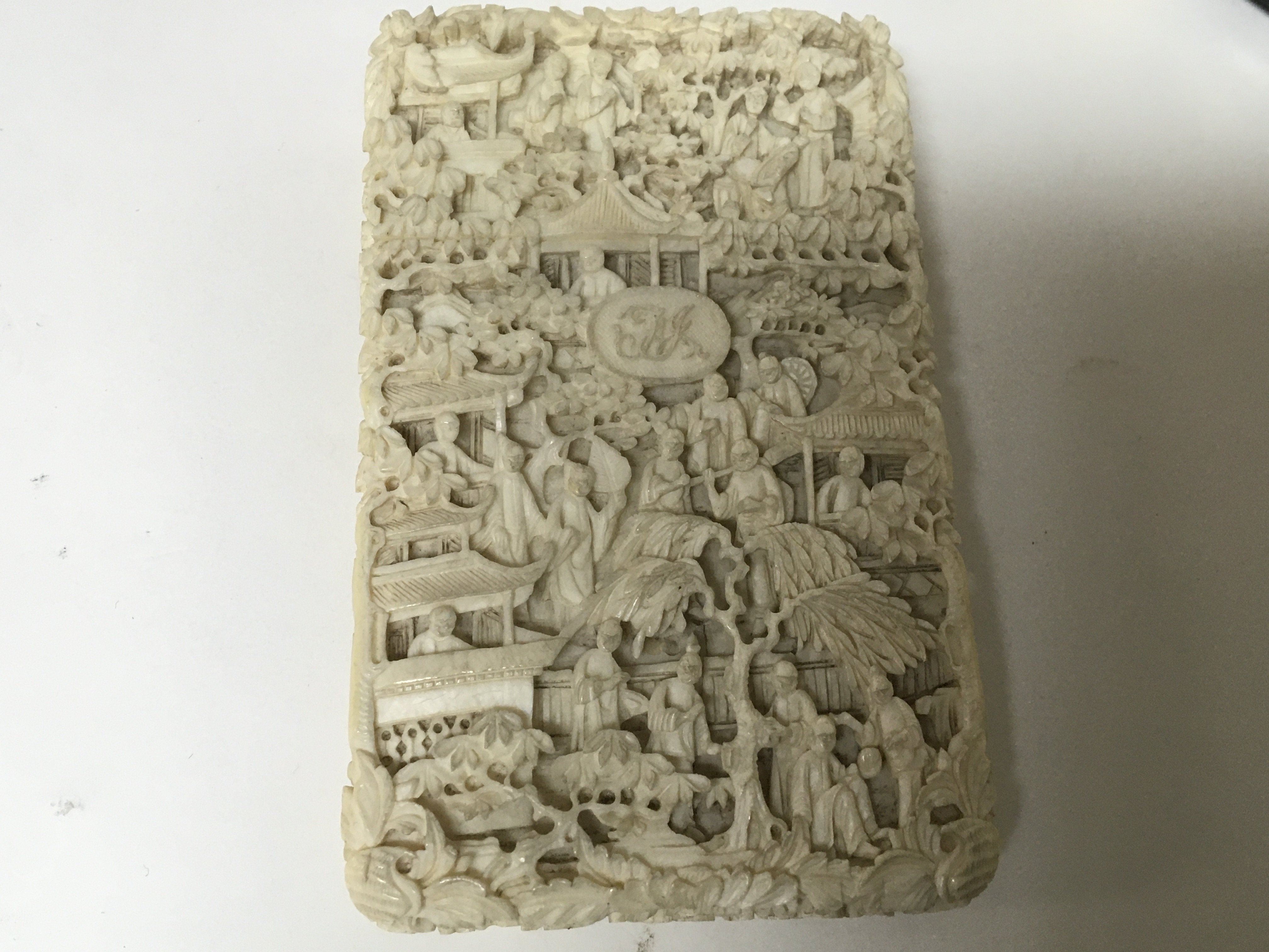 A Quality late 19th century carved ivory card case profusely carved with figures.