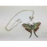 A silver butterfly necklace set with rubies and ma