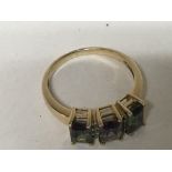 An unmarked gold ring inset with three Alexandrite stones ring size N.