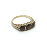 An unmarked gold ring set with three garnets and f