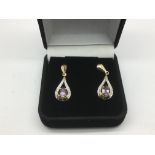 A pair of 9ct gold drop earrings set with amethyst