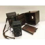 A cased Rolleiflex camera and an old plate camera