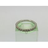 An 18ct white gold half hoop eternity ring set wit