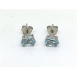 A pair of silver studs set with blue topaz.