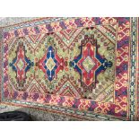 A hand knotted rug the centre field with three medallion on a green ground with a patterned