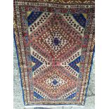 A hand Knotted Turkish or Middle Eastern rug with two patterned diamonds on a blue ground with an