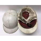 Two vintage motorcycle or scooter helmets