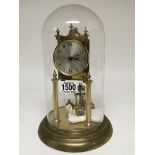 A brass 400 day Anniversary clock with a silvered dial under a glass dome.