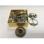 A collection of silver brooches.