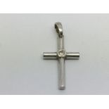 A white gold crucifix set with a solitaire diamond