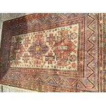 A hand knotted Turkish or Middle Eastern rug with a wide patterned boarder central ivory field
