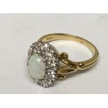 An 18carat gold ring set with an opal and brilliant cut diamond in an oval ring size N.