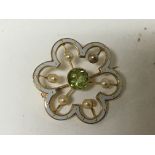 A 15carat gold and white enamel brooch set with pearl and a central green stone possible a green