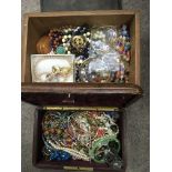 Two jewellery boxes containing costume jewellery items.