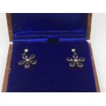 A boxed pair of daisy style earrings set with amet