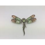 A silver dragonfly brooch set with peridot, ruby e