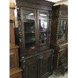 A oak book case cupboard the pair of glazed doors above a single drawer And carved cupboards