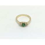 An 18ct gold three stone heart shaped emerald and
