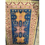 A hand knotted Middle Eastern rug with a pink ivory patterned boarder with three central medallion