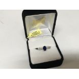 An 18carat white gold ring set with a blue sapphire the shank with small diamonds. Ring size N