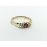 An 18ct gold ring set with a central ruby and a di