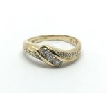 An 18ct gold three stone diamond ring with further diamonds to the shoulders, approx 2.7g and approx