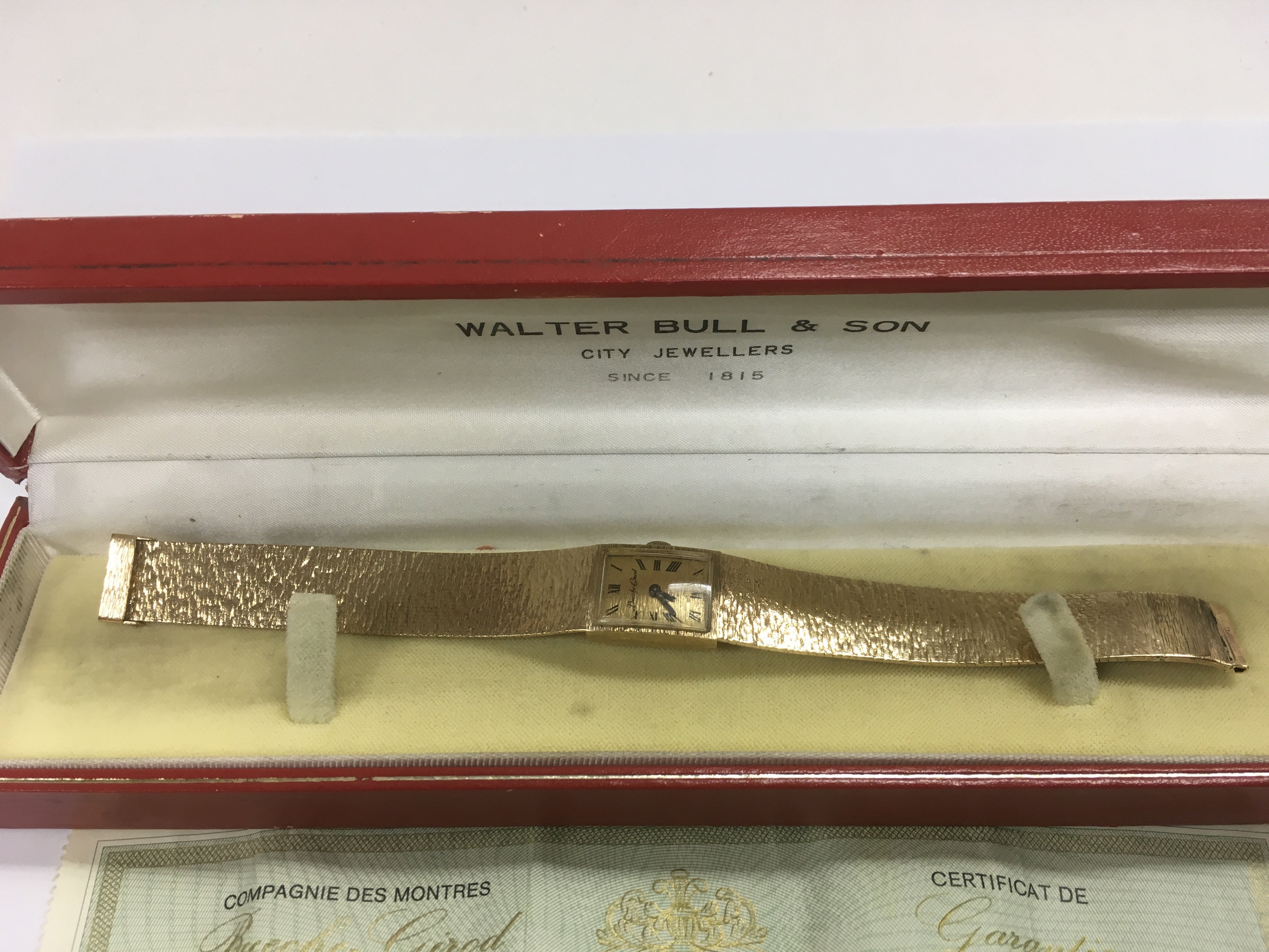 A cased 9ct gold Bueche Girod watch with associated paperwork.