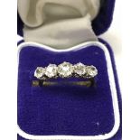 A gold band ring inset with five old cut diamonds