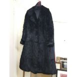 A black mid length rabbit fur coat