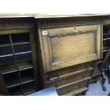 An oak cabinet with a fall front above drawers fla