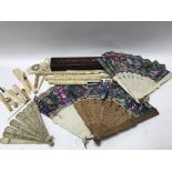 A collection of carved ivory fans and parasol hand