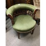 A walnut arm chair with a green upholstered top ra