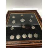A collection of silver sporting medallions in a oa