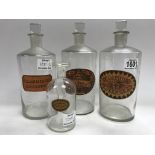 Four glass medicine bottles with labels