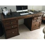 A modern polished hardwood office desk with a leat