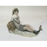 A Lladro figure in the form of a young boy with a